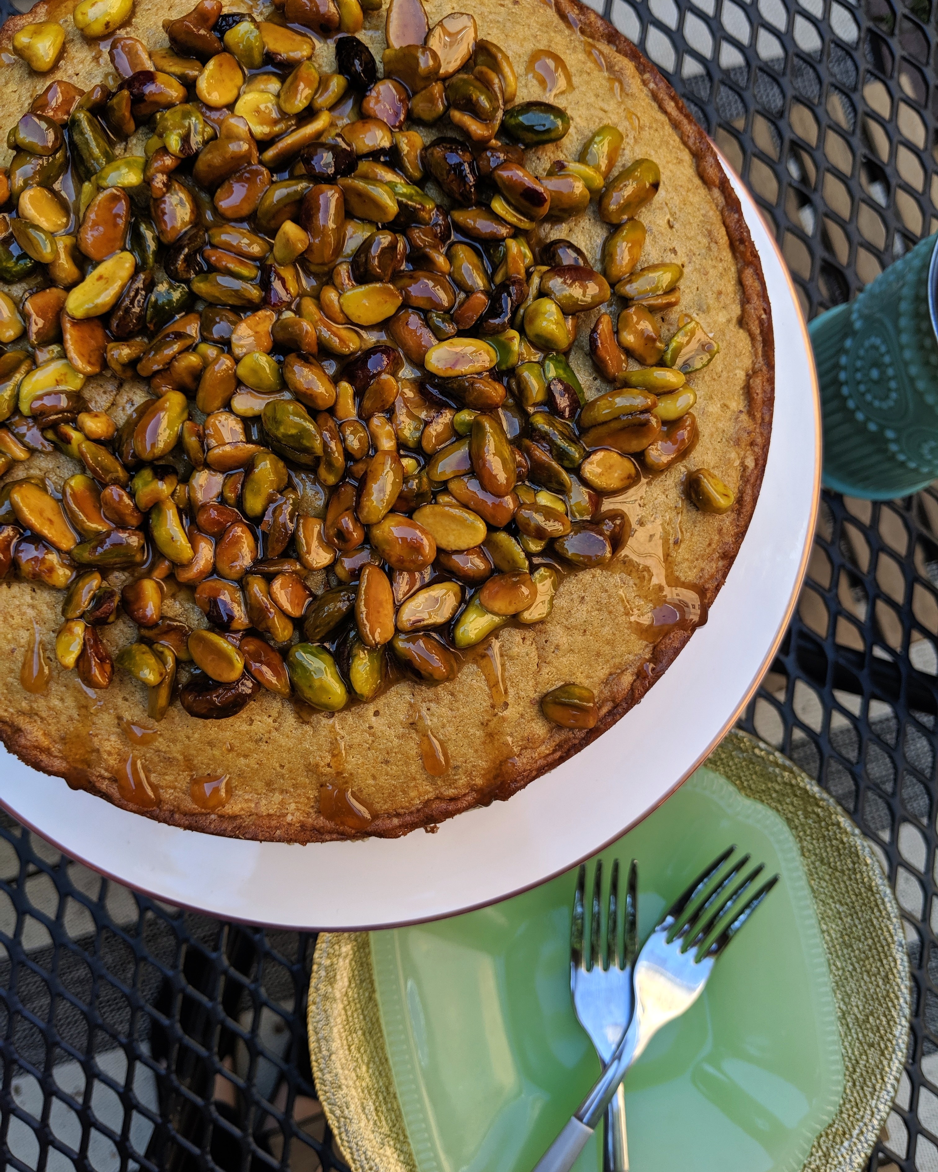 Top-down image of pistachio cake with honey-glazed pistachios on top